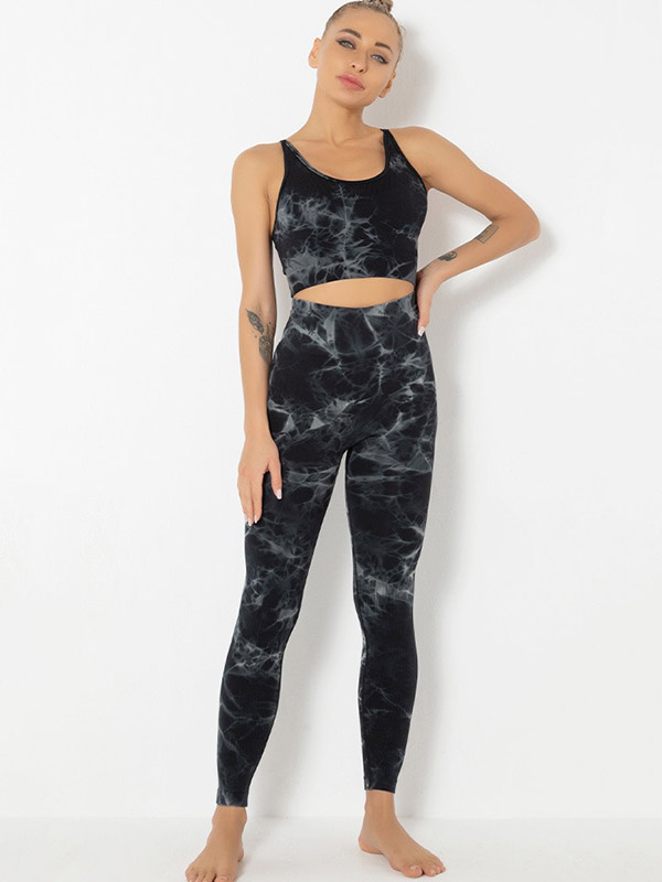 Woman wearing a stylish black printed sports bra and leggings, perfect activewear for yoga. Comfortable and breathable nylon outfit.